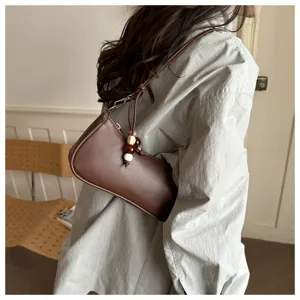 Detailed view of trendy brown PU leather underarm shoulder bag featuring elegant beaded charm.
