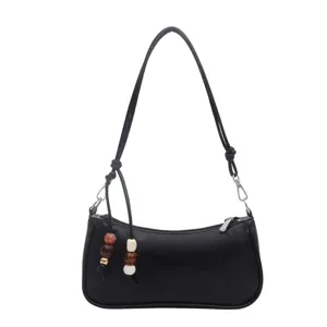 Classic black PU leather shoulder bag for women, stylish underarm bag with chic bead pendants.