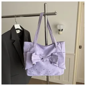 Vista dettagliata di una borsa tote viola chiaro con grande fiocco e stelle.