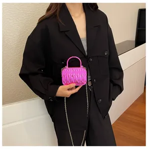 Detail view of the metallic pink pleated mini crossbody bag with chic chain strap.