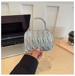 Silver metallic pleated mini handbag with metal handle and trendy chain strap for women.