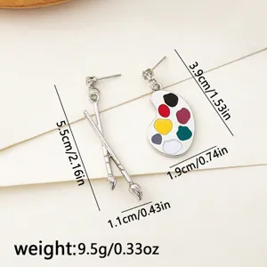 Asymmetrical paintbrush and palette earrings, cute art student style jewelry detail view.