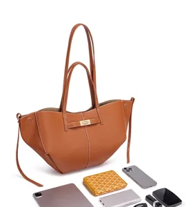 Detailaufnahme der braunen Leder-Tote-Bag mit grossem Fassungsvermoeggen und Alltags-Accessoires.
