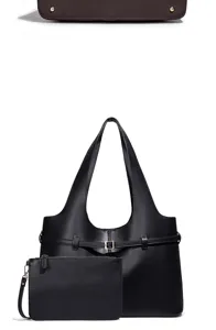 Detailweergave van zwarte lederen tote tas met bijpassende etui en metalen nopjes.