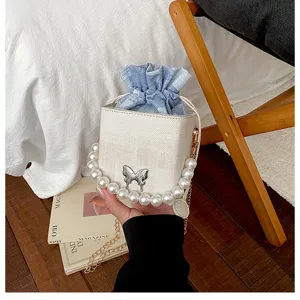 Stylish women drawstring bucket bag with pearl handle, metal butterfly and plaid inner pouch.