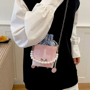 Pink pearl bucket bag with chain strap, stylish denim drawstring crossbody bag for women.