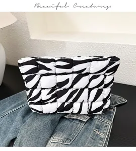 Gedetailleerde close-up van een zwart-witte, gewatteerde cosmetische tas met een trendy pofontwerp.