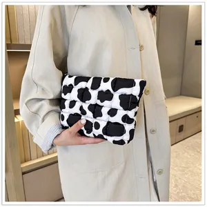 Zwart-witte koeienprint gewatteerde clutch, zachte minimalistische make-up tas voor dames.