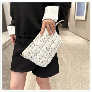 Gewatteerde witte clutch met schattige kersenprint, gedetailleerd zicht op zachte stof en rits.