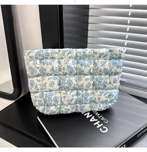 Gedetailleerd overzicht van de blauwe bloemengewatteerde cosmetische tas, zachte etui.