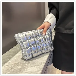 Zilveren metallische puffer clutch tas detail met gewatteerde textuur en glanzende