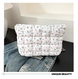 Gedetailleerd overzicht van een witte gewatteerde cosmetische tas met schattige kersenprint.