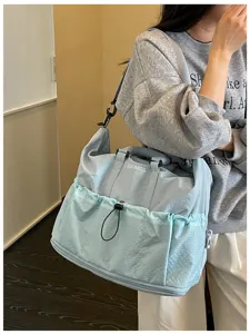 Hellblaue Reise-Duffeltasche mit Kordelzug-Vorderentasche und bequemem Schultergurt.