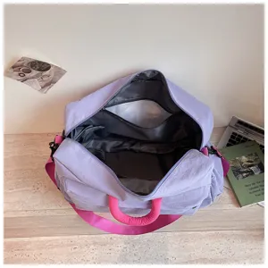 Grand sac de voyage et de sport violet avec des poignées roses pour week-end et loisirs.
