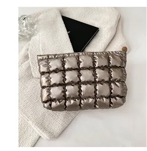 Gedetailleerd overzicht metallic gewatteerde clutch, zachte cosmetische tas met glans.