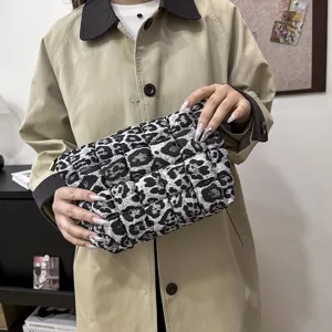 Gedetailleerd overzicht van gewatteerde luipaardprint clutch, trendy tas voor dames.