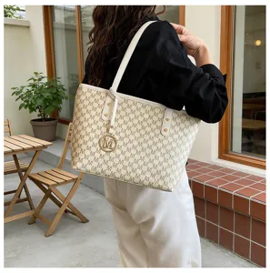 Detailansicht der stylischen Tasche mit Monogramm-Muster und schicker Metallverzierung.