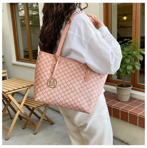 Detailansicht der stilvollen rosa Monogramm-Tasche mit goldenem M-Anhänger im Café.