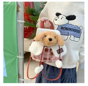 Détail du sac à dos en peluche pour chien avec design de tête duveteux et motif à carreaux.