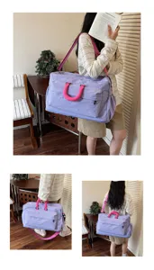 Grand sac de voyage violet avec des poignees roses pour week-end et sport.