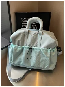 Nahaufnahme der hellblauen Reisetasche mit praktischen Vordertaschen und Griffen.