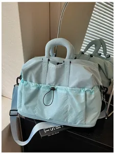 Detailansicht der hellblauen Reise-Duffeltasche mit mehreren Taschen und großem Stauraum.