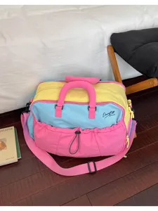 Detail der bunten Dopamin-Reisetasche mit leuchtenden Rosa-, Gelb- und Blautönen.