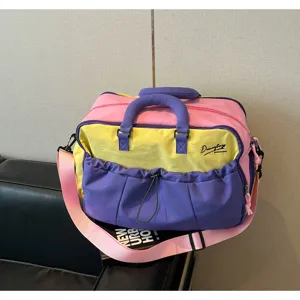 Detailaufnahme der bunten Reisetasche, leuchtendes Pink Gelb Lila Design mit Schultergurt.