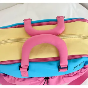 Farbblock-Reisetasche Detail, zeigt leuchtende rosa Griffe und Reißverschlussstruktur.