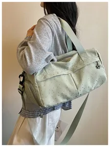 Nahaufnahme der salbeigrünen Reisetasche mit Sternenprint am Model, zeigt den Stil.