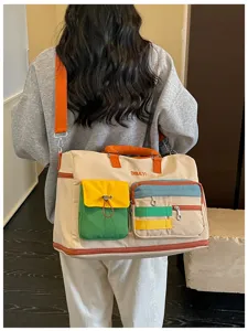 Detailed view of the colorful color-block travel duffel bag showing multiple pockets and strap.