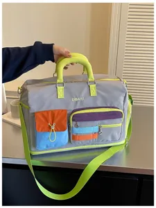 Color-block travel duffle bag with multiple pockets, neon green handles and adjustable strap.