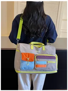 Color-block travel duffel bag detail, showcasing vibrant multi-pocket design and strap.