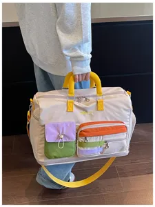 Detail view of the colorful multi-pocket canvas travel duffel bag with durable yellow straps.
