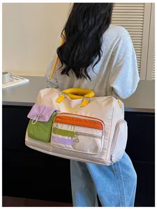 Color-block travel bag, large capacity weekend duffel, stylish commuting storage bag for women.