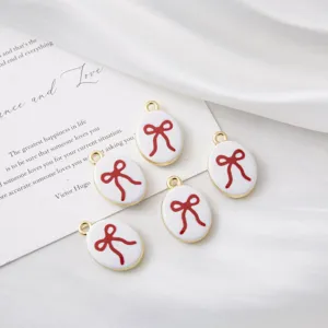 Detailed shot of oval enamel red bow charms, perfect for DIY jewelry and handmade necklace making.