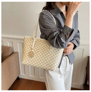 Detailansicht der Damen Handtasche im Herbst mit klassischem Monogramm und weissen Henkeln.
