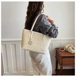 Detailansicht der modischen Damen-Shopper-Tasche mit stilvollem Monogramm-Muster und Henkel.