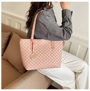 Elegante Damen Rosa Shopper Handtasche mit Monogramm Muster und goldenem Anhänger für Pendler.