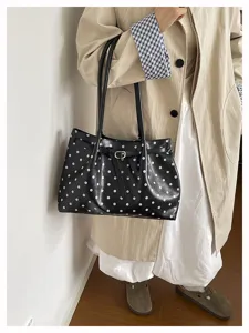Primo piano dettagliato della borsa a tracolla elegante a pois neri e bianchi.