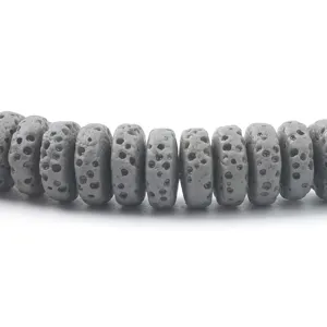 Dettaglio di perline distanziatrici in pietra lavica porosa grigia per gioielli e bracciali.