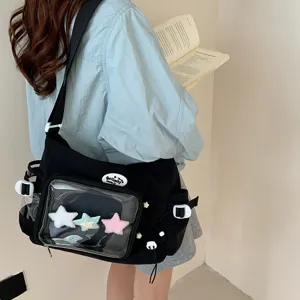 Black canvas ita bag with clear front pocket, shoulder strap, and plush stars for daily use.
