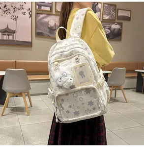 Detail shot of the cute star-patterned canvas backpack featuring a plush pendant and card holder.