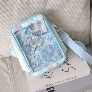 Light blue mini ita bag detail showing transparent front pocket with cute anime inserts and charms.