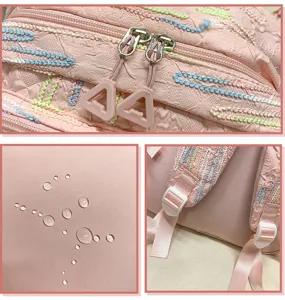 Pink backpack detail view showing exquisite embroidery, smooth zippers and adjustable straps.