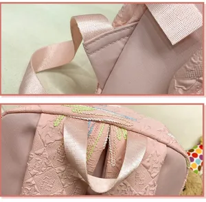 Pink Ita backpack detail shot showing shoulder straps, textured fabric and cute embroidery.