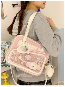 Detalle de bolso ita de peluche rosa con ventana transparente y bonitos pines anime.