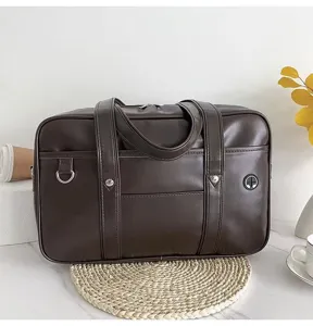Dark brown PU leather JK uniform bag detail showing dual handles, front pocket and D-ring.