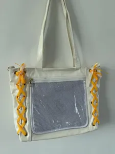 White Japanese style ita bag detail showing clear front window, mesh pocket and ribbon lacing.