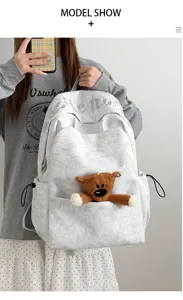 Vista detallada de la mochila gris informal con bonito colgante de osito de peluche.